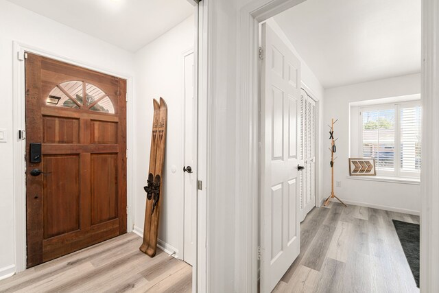 entryway with baseboards and light wood-style flooring