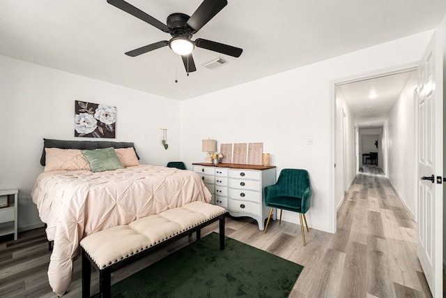 bedroom with visible vents, baseboards, light wood-style flooring, and a ceiling fan