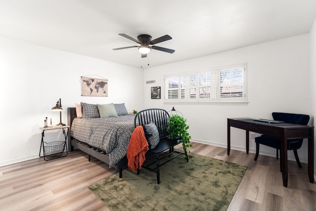 bedroom featuring wood finished floors, baseboards, and ceiling fan