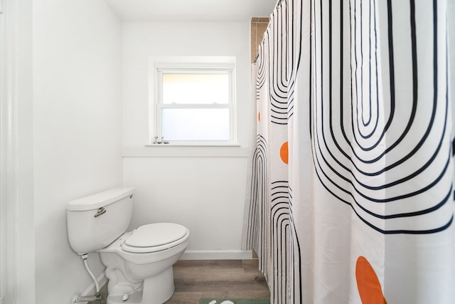 full bathroom with a shower with curtain, baseboards, toilet, and wood finished floors