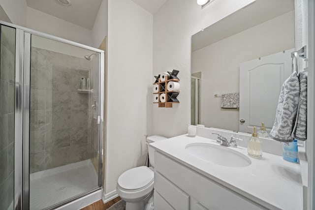 full bathroom with a stall shower, toilet, and vanity