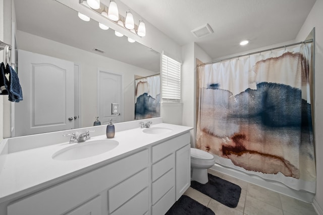 bathroom featuring tile patterned flooring, double vanity, visible vents, and a sink