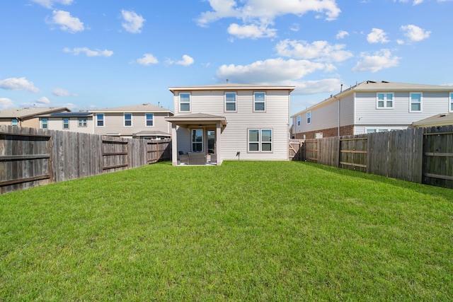 back of house with a fenced backyard and a yard