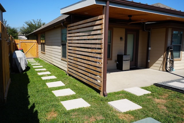 exterior space featuring a gate, a patio area, a yard, and fence