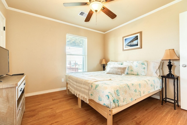 bedroom featuring crown molding, wood finished floors, visible vents, and baseboards