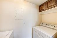 washroom with cabinet space and washing machine and clothes dryer