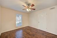 spare room featuring dark wood-style floors, baseboards, and a ceiling fan