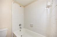 full bathroom with toilet and tub / shower combination