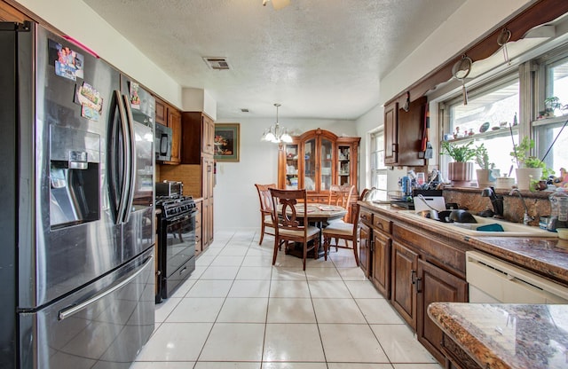 kitchen with black range with gas stovetop, visible vents, stainless steel fridge with ice dispenser, dishwasher, and a sink