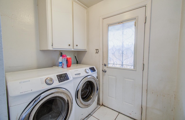 laundry room featuring cabinet space, light tile patterned flooring, and separate washer and dryer