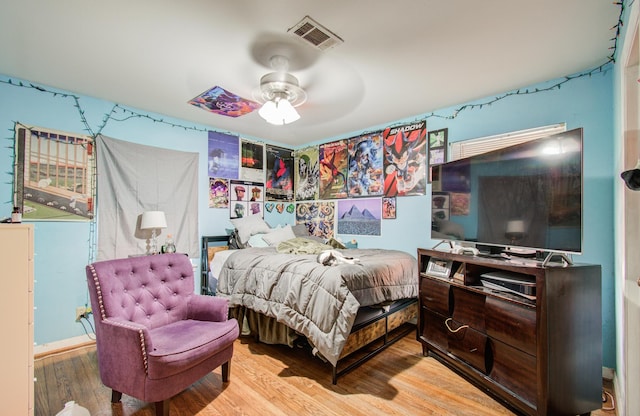 bedroom featuring wood finished floors, visible vents, and ceiling fan