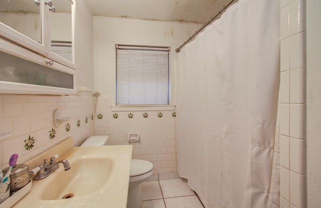 bathroom with a shower with curtain, toilet, a sink, tile walls, and tile patterned flooring