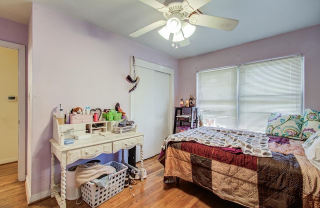 bedroom with a ceiling fan, light wood-type flooring, a closet, and baseboards