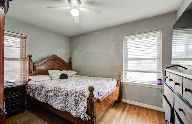 bedroom featuring wood finished floors, baseboards, and ceiling fan