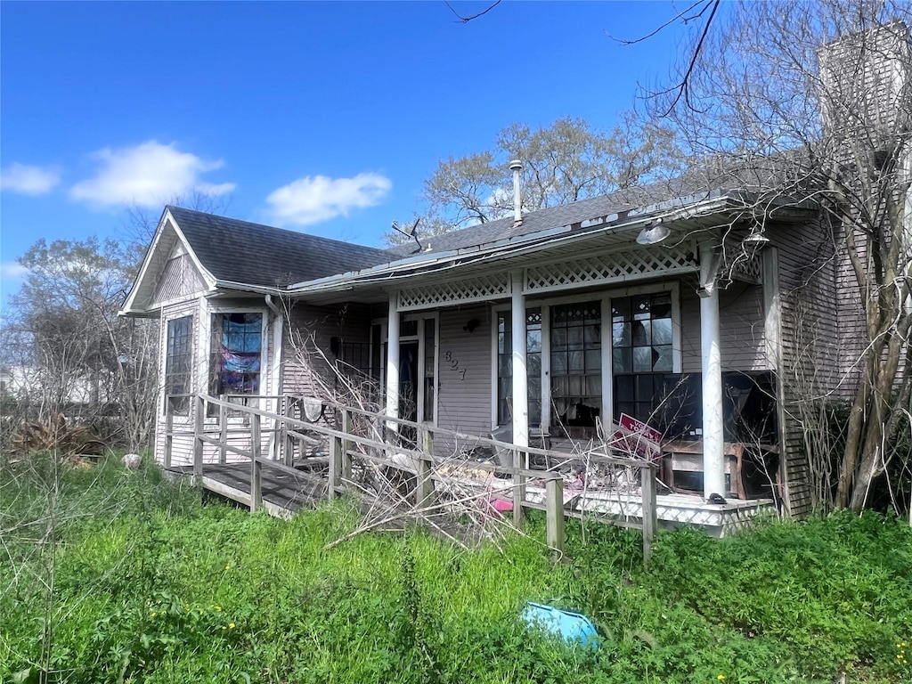 rear view of property with a shingled roof