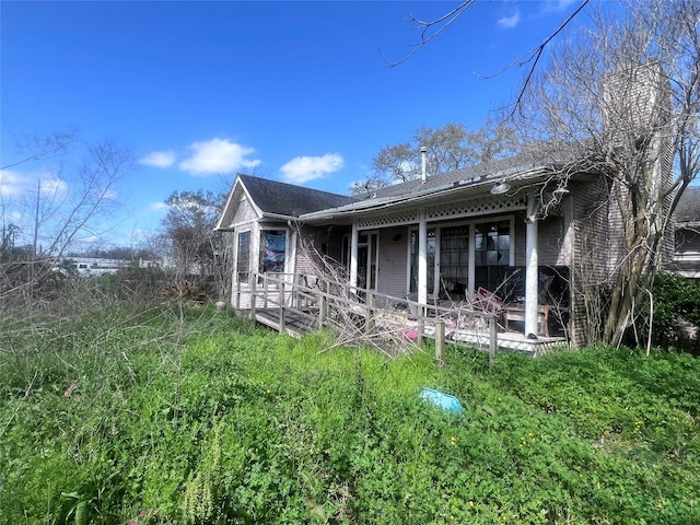 back of house with a shingled roof