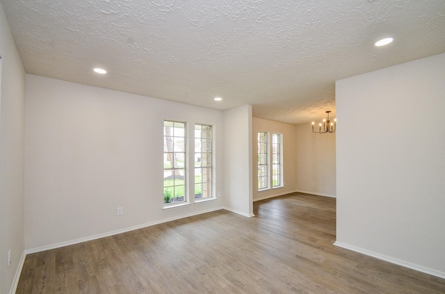 empty room featuring recessed lighting, wood finished floors, and baseboards
