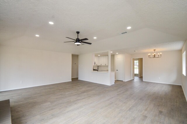 unfurnished living room featuring recessed lighting, ceiling fan with notable chandelier, a textured ceiling, and light wood-type flooring