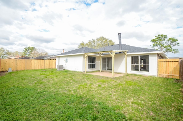 rear view of property featuring a patio, central air condition unit, a yard, and a fenced backyard