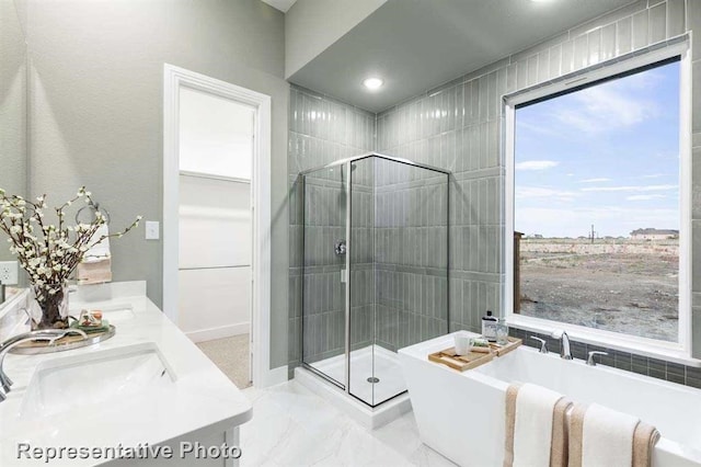 full bathroom with marble finish floor, a sink, a shower stall, double vanity, and a soaking tub