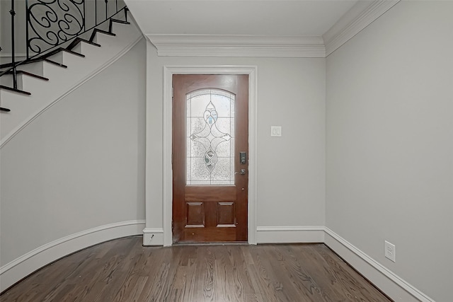 foyer entrance featuring stairway, dark wood-type flooring, and ornamental molding