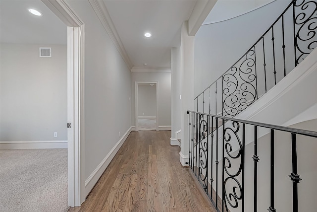 corridor with visible vents, ornamental molding, wood finished floors, recessed lighting, and baseboards