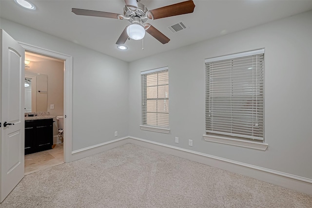 unfurnished bedroom with a ceiling fan, visible vents, recessed lighting, ensuite bathroom, and light carpet