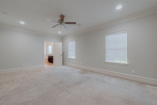 unfurnished room featuring a ceiling fan, crown molding, light colored carpet, and baseboards