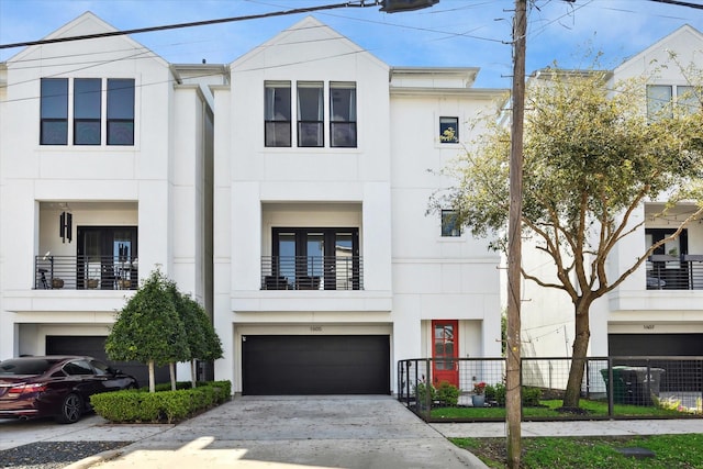 view of front of home featuring stucco siding, concrete driveway, and fence