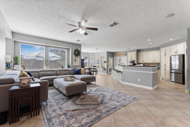 living room featuring light tile patterned floors, visible vents, recessed lighting, and a ceiling fan