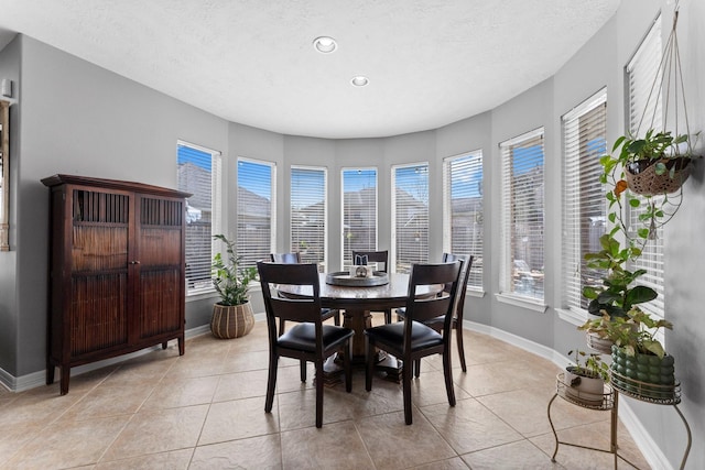 dining room with recessed lighting, baseboards, a textured ceiling, and light tile patterned flooring