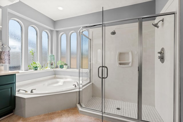 bathroom with tile patterned floors, a garden tub, a stall shower, and vanity