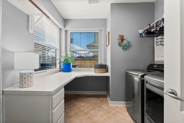 clothes washing area with baseboards, visible vents, laundry area, light tile patterned flooring, and washing machine and dryer