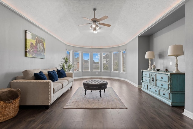 living room featuring dark wood-style floors, baseboards, a textured ceiling, and a tray ceiling