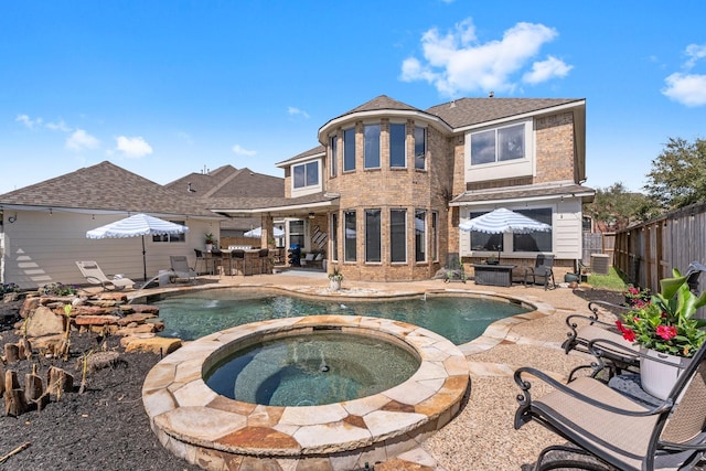 back of property with a fenced in pool, an in ground hot tub, a fenced backyard, and a patio area