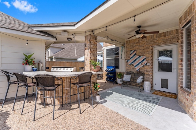 view of patio / terrace with fence, outdoor dry bar, and ceiling fan