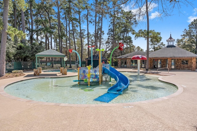 view of swimming pool with a gazebo, playground community, and fence