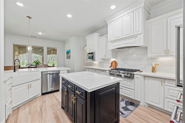 kitchen with a sink, dark cabinetry, stainless steel appliances, white cabinets, and light countertops