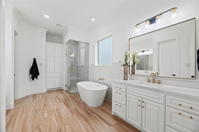 bathroom featuring visible vents, ornamental molding, wood finished floors, a marble finish shower, and a soaking tub