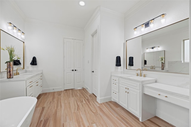 bathroom featuring ornamental molding, wood finished floors, two vanities, and a sink