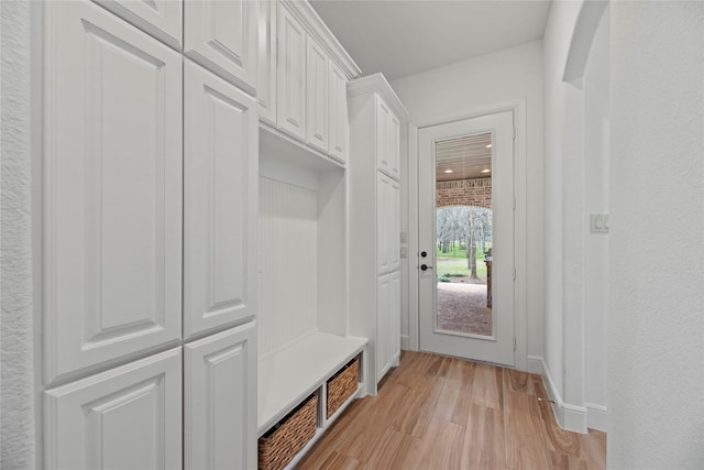 mudroom with baseboards, light wood-type flooring, and a textured wall