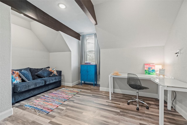 home office featuring baseboards, lofted ceiling, and wood finished floors