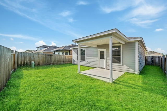 back of property featuring a lawn, a fenced backyard, and a patio area