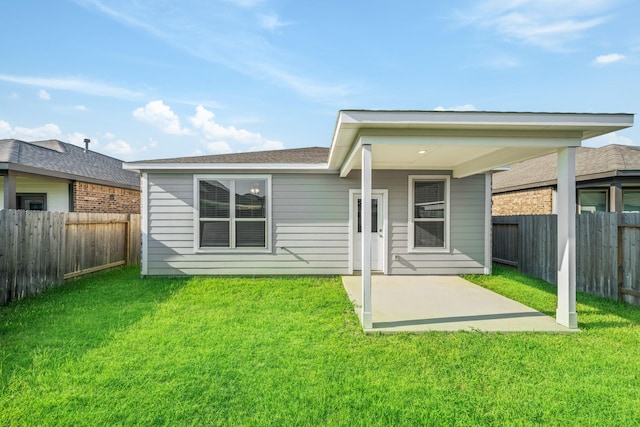 back of house with a patio area, a lawn, and a fenced backyard