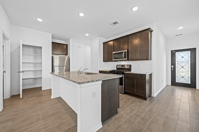 kitchen featuring visible vents, dark brown cabinets, appliances with stainless steel finishes, and a sink