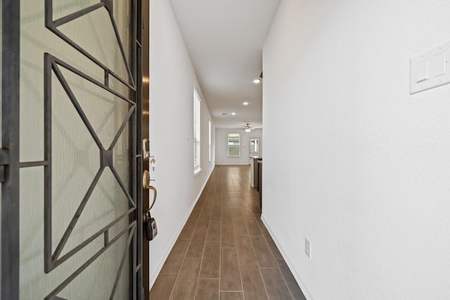 hallway with recessed lighting and baseboards