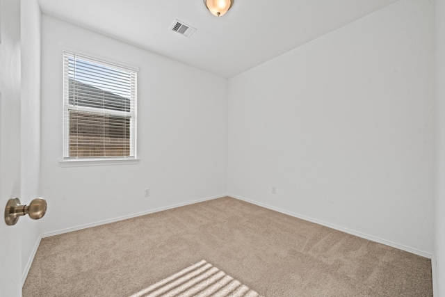 carpeted empty room featuring baseboards and visible vents