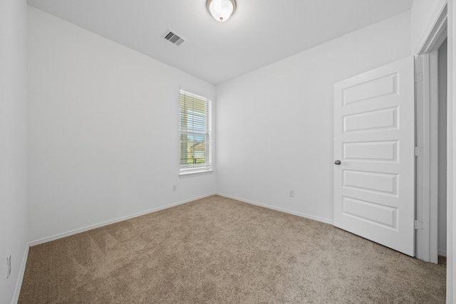 spare room featuring visible vents, carpet flooring, and baseboards