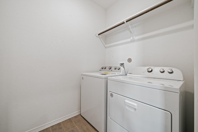 laundry room featuring laundry area, baseboards, wood finish floors, and separate washer and dryer