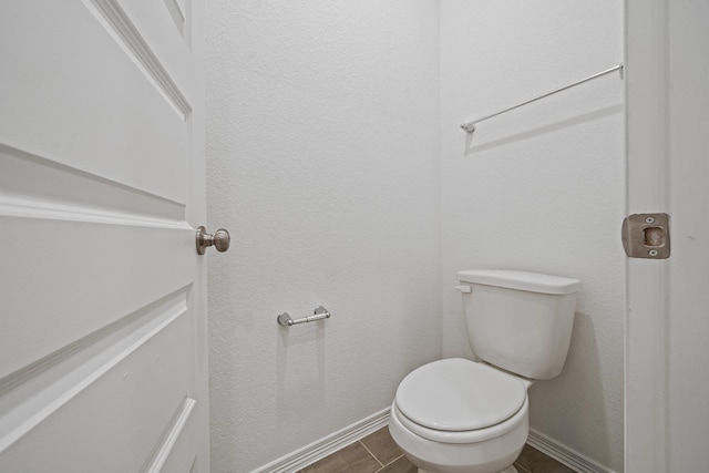 bathroom with toilet and baseboards